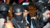 Radical Islamic cleric Aman Abdurrahman, center, is escorted by police officers after his sentence hearing at South Jakarta District Court in Jakarta, June 22, 2018. Abdurrahman was sentenced to death by an Indonesian court.