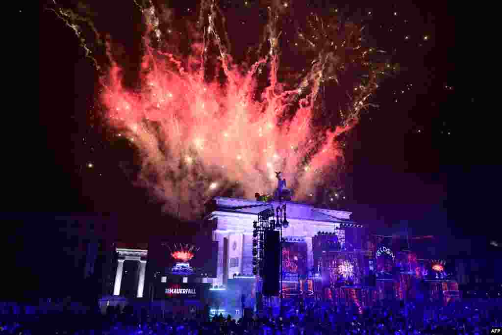 Fireworks ligthen the sky over the Brandenburg gate as musicians play on stage during the Konzert für Freiheit" (concert for freedom) for the 35th anniversary of the fall of the Berlin Wall, Nov. 9, 2024 in Berlin, Germany.