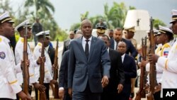 FILE - Haiti's President Jovenel Moise, center, leaves the museum during a ceremony marking the 215th anniversary of revolutionary hero Toussaint Louverture's death, at the National Pantheon museum in Port-au-Prince.