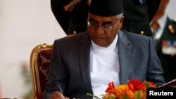 Newly elected Nepalese Prime Minister Sher Bahadur Deuba signs the oath after swearing-in ceremony at the presidential building in Kathmandu, Nepal, June 7, 2017.