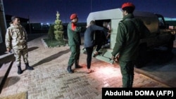 Des soldats de la police militaire pro-Haftar escortent un véhicule des prisonniers capturés par les forces du général Haftar. Photo prise à Benghazi, dans l'est de la Libye le 5 mai 2020.