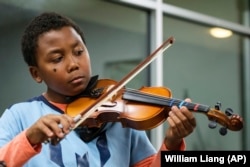 Johnathan Nealy plays the violin as part of a string music program at New Hope Presbyterian Church on Wednesday, Oct. 16, 2024, in Anaheim, California. (AP Photo/William Liang)