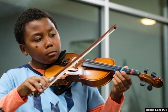 Johnathan Nealy plays the violin as part of a string music program at New Hope Presbyterian Church on Wednesday, Oct. 16, 2024, in Anaheim, California. (AP Photo/William Liang)