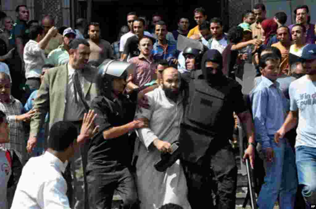 Egyptians security forces escort an Islamist supporter of the Muslim Brotherhood out of the al-Fatah mosque, Aug. 17, 2013.