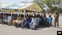 Wanaume waliokuwa wametiwa mbaroni na jeshi la Nigeria lakini hawana uhusiano na Boko Haram wakiwa wamekaa kwenye hema kabla ya kuachiwa huru.