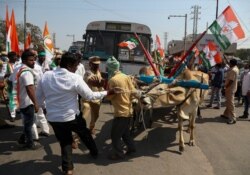Congress party activists block a highway during a nationwide shutdown called by thousands of Indian farmers protesting new agriculture laws in Hyderabad, India, Feb. 6, 2021.