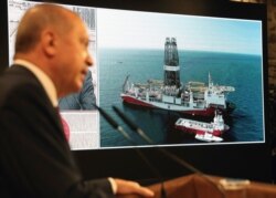 FILE - Turkey's President Recep Tayyip Erdogan speaks with Turkish drilling ship, Fatih, in background, in Istanbul, Aug. 21, 2020.