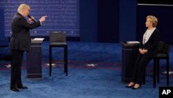 FILE - Then Republican presidential nominee Donald Trump speaks to then Democratic presidential nominee Hillary Clinton during the second presidential debate at Washington University in St. Louis, Missouri, Oct. 9, 2016.