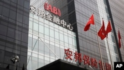 A worker cleans windows of the Anbang Insurance Group's building in Beijing, March 16, 2016. Anbang is in a bidding war with Marriott for the acquisition of Starwood Hotels & Resorts.