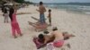 FILE-A Cambodian woman gives massage to a tourist on the beach of Sihanoukville, some 185 kilometers (115 miles) southwest of Phnom Penh, Cambodia, file photo. (AP Photo/Heng Sinith)