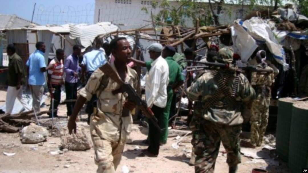 Police and soldiers gather at the site of a suicide blast near the compound of Somali President Sharif Sheikh Ahmed, Mogadishu, March 14, 2012.