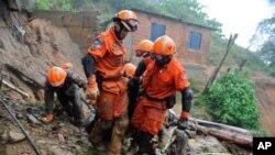 Para petugas pemadam kebakaran mengevakuasi korban tanah longsor di Petropolis, 65 kilometer utara Rio de Janeiro, Brazil (18/3). Sedikitnya 27 orang dilaporkan tewas dalam insiden tanah lonsor ini.