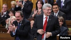 El primer ministro canadiense, Stephen Harper (derecha) vota la moción de participar en la coalición contra el grupo Estado islámico.