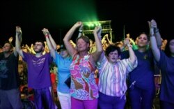 Audience members join hands in worship at the Franklin Graham Decision America event at the Pitt County Fairgrounds in Greenville, N.C., Oct. 2, 2019.