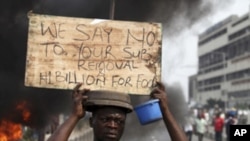 A protester carries a placard on the second day of a protest against a removal of fuel subsidies in Lagos, January 10, 2012.