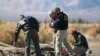 Investigators from the National Transportation Safety Board (NTSB) look at wreckage from the crash of Virgin Galactic's SpaceShipTwo near Cantil, California, Nov. 2, 2014. 