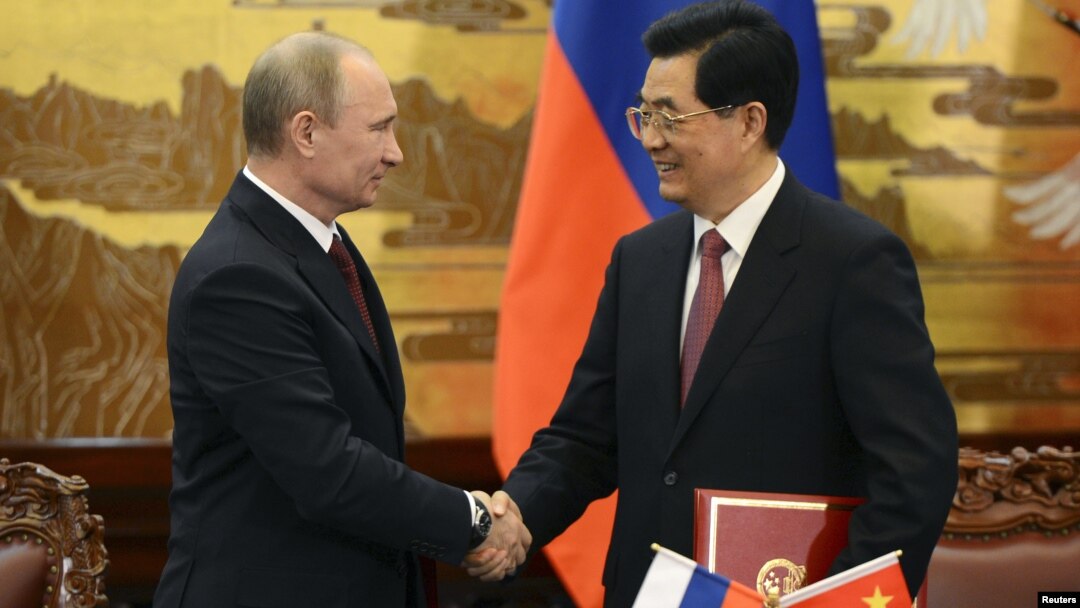 China's President Hu Jintao and Russian President Vladimir Putin shake hands in Beijing, June 5, 2012.