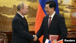 China's President Hu Jintao and Russian President Vladimir Putin shake hands in Beijing, June 5, 2012.