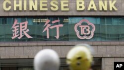 FILE - In this file photo from Jan. 16, 2007, motorcyclists pass by a branch of The Chinese Bank in Taipei, Taiwan. 