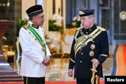 Malaysian King Sultan Ibrahim Iskandar (right) speaks with Prime Minister Anwar Ibrahim after the swearing-in ceremony at the National Palace in Kuala Lumpur, Malaysia, Wednesday (31/1).