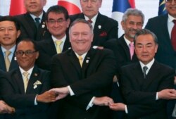 U.S. Secretary of State Mike Pompeo crosses his arms for the traditional "ASEAN handshake" with Chinese FM Wang Yi and fellow diplomats, during the 26th ASEAN Regional Forum, Bangkok, Thailand, Aug. 2, 2019.