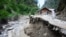 Warga desa berjalan di jalan yang hancur diterjang banjir di Lembah Neelum Valley, di wilayah Kashmir yang dikuasai Pakistan, 15 Juli 2019. 