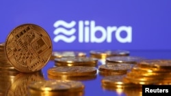 FILE - Representations of virtual currency are displayed in front of the Libra logo in this illustration picture.