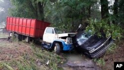 Un camión y un automóvil se encuentran en un arroyo el domingo 22 de agosto de 2021, después de que fueron arrastrados el día anterior en McEwen, Tennessee, EE. UU.
