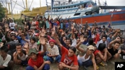 Para nelayan Myanmar mengangkat tangan mereka saat ditanya siapa yang ingin pulang, di pulau Benjina, Kepulauan Aru, Maluku (3/4). (AP/Dita Alangkara)