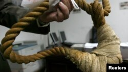 FILE - A museum worker shows a noose on display in a Iraqi museum in Baghdad, December 30, 2008.