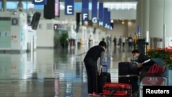 A woman, wearing a face mask following the coronavirus disease (COVID-19) outbreak, sorts luggage at Hong Kong International Airport in Hong Kong, China October 20, 2020. REUTERS/Lam Yik