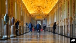 ARCHIVO - Trabajadores de museo caminan por un pasillo de los Museos Vaticanos antes de la apertura, en el Vaticano, el lunes 1 de febrero de 2021. 