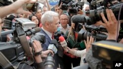 Pemimpin partai Sosial Demokrat yang berkuasa di Rumania, Liviu Dragnea, dikelilingi awak media saat ia tiba di kantor jaksa anti-korupsi di Bukares, Rumania, 27 April 2018 (foto: AP Photo/Vadim Ghirda)