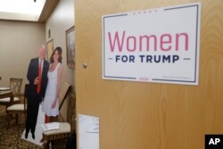 A cutout of President Trump and his wife Melania is shown outside a training session for Women for Trump, An Evening to Empower, in Troy, Mich., Aug. 22, 2019.