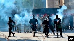 Iraqi security forces fire tear gas to disperse anti-government protesters during a demonstration in central Baghdad, Oct. 25, 2019. Iraqi police fired tear gas to disperse thousands of protesters.