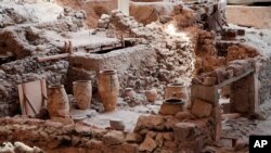 In this handout photo provided by the Greek Prime Minister's Office , ancient jars are seen inside the 16th century BC archaeological site of Akrotiri at the Greek island of Santorini. Greece is hoping its tourism season takes off.