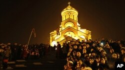 Georgians attend Orthodox Christmas celebrations at the Holy Trinity Cathedral in Tbilisi, early Saturday, Jan. 7, 2012. Christmas falls on Jan. 7 for Orthodox Christians that use the old Julian calendar instead of the 16th-century Gregorian calendar adop