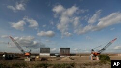 FILE - The first panels of levee border wall are seen at a construction site along the U.S.-Mexico border, Nov. 7, 2019, in Donna, Texas. The new section, with 18-foot tall steel bollards atop a concrete wall, will stretch approximately 8 miles.