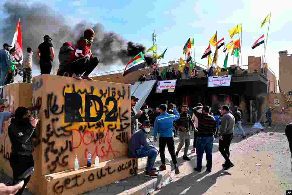 Pro-Iranian militiamen and their supporters set a fire during a sit-in in front of the U.S. embassy in Baghdad, Iraq. U.S. troops fired tear gas to disperse pro-Iran protesters who were gathered outside the embassy compound for a second day.