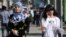 A woman, wearing a headscarf according to the Islamic dress code, walks next to a women dressed in a western style on a street of Dushanbe September 18, 2010. Chronic poverty and a Soviet-style crackdown on religion is fuelling the growth of radical Islam