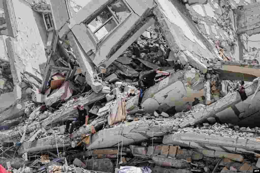 Palestinian workers clear rubble and debris in Gaza City&#39;s al-Rimal neighborhood, which was targeted by Israeli strikes during the recent confrontation between Hamas and Israel.