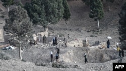 Residents gather near a damaged house on Dec. 26, 2024, two days after airstrikes by Pakistan in the Barmal district of eastern Paktika province.