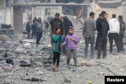 Gadis-gadis Palestina berjalan di lokasi serangan Israel terhadap sebuah rumah, di tengah konflik yang sedang berlangsung antara Israel dan Hamas, di Kota Gaza, 5 Januari 2025. (Foto: REUTERS/Dawoud Abu Alkas)