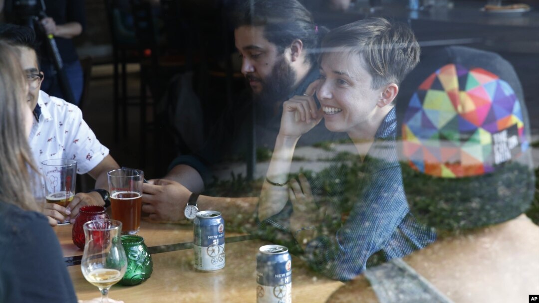 Diana Downard, 26, a Bernie Sanders supporter who now says she will vote for Hillary Clinton, has drinks with friends at a pub in Denver, July 6, 2016. 