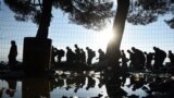 The sun rises as refugees and migrants walk to pass from the northern Greek village of Idomeni to southern Macedonia, Sept. 11, 2015. The sudden onset of autumn has taken tens of thousands by surprise all along the Balkans route from Greece to Hungary.