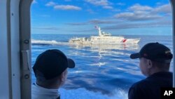 Sebuah kapal penjaga pantai China bermanuver di samping kapal penjaga pantai Filipina BRP Cabra saat mereka mendekati Second Thomas Shoal di Laut China Selatan yang disengketakan, 10 November 2023. (Foto: AP)