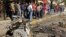 Residents are seen inspecting the site of a car bomb attack in the Karrada district in Baghdad February 17, 2013.