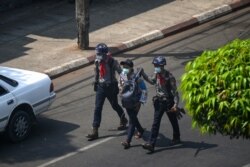 FILE - Police arrest a Myanmar Now journalist in Yangon, February 27, 2021, as protesters were taking part in a demonstration against the military coup.