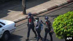 FILE - Police arrest a Myanmar Now journalist in Yangon, February 27, 2021, as protesters were taking part in a demonstration against the military coup.