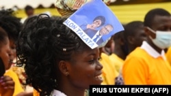 Une femme portant un tract de campagne électorale du Président sortant Patrice Talon et de sa colistière Mariam Talata participe à un meeting de campagne à Abomey-Calavi, le 9 avril 2021.